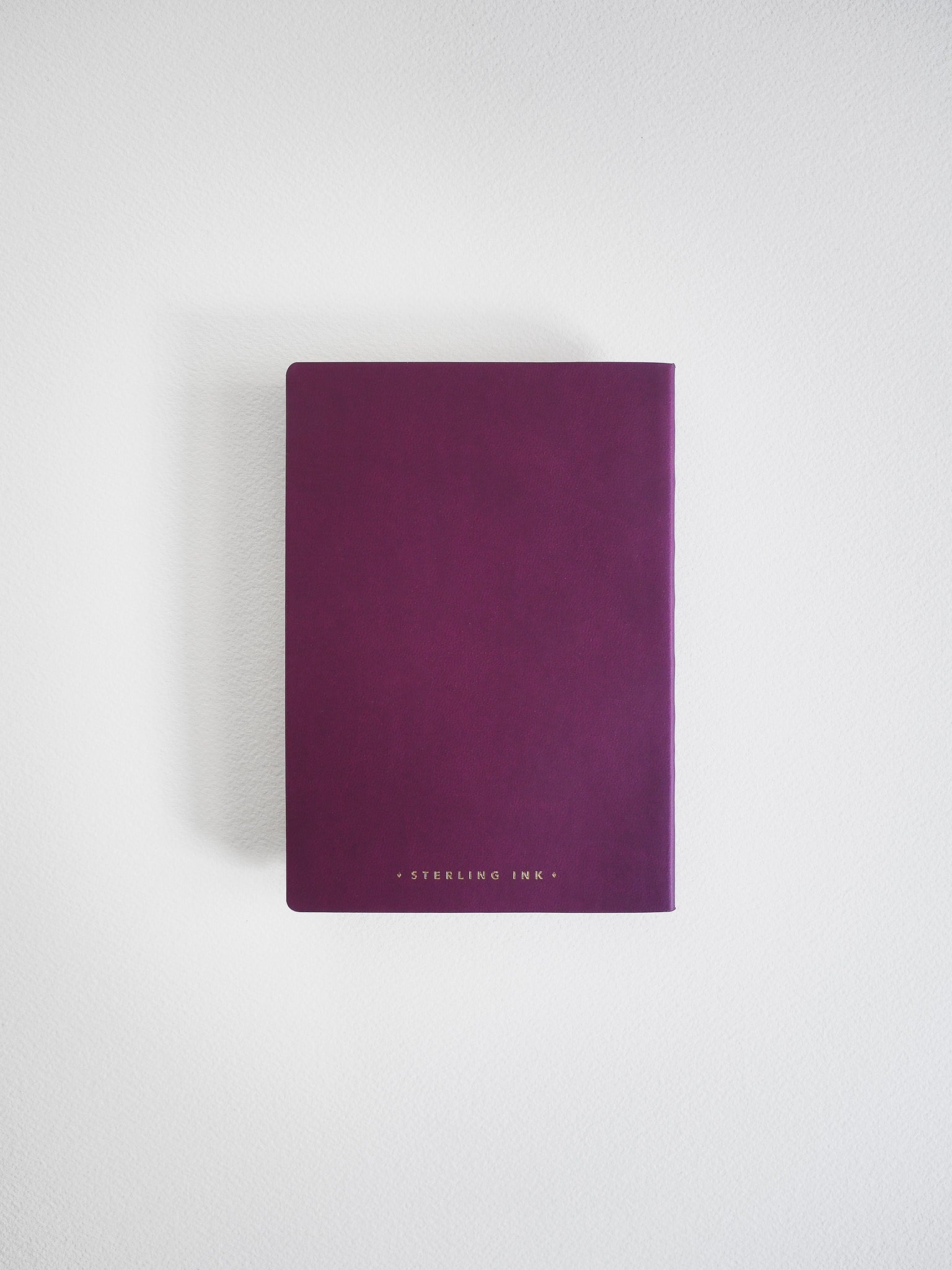 Solid dark purple A6 grid notebook featuring a minimalist white "Sterling Ink" logo, perfect for writing or studying.