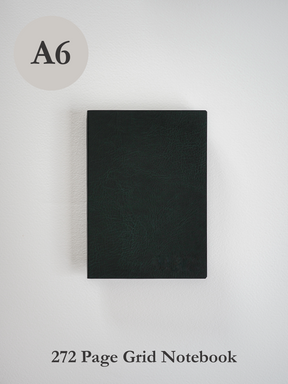 Solid black A6 grid notebook featuring a durable, smooth matte faux leather cover, perfect for minimalist writing and planning.