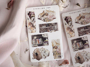Vintage scrapbook stickers featuring distressed torn paper, small antique indoor scenes, and stacks of worn books from the December 2023 collection.