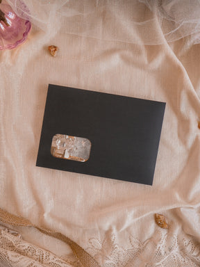 Sleek black kit card highlighting a centrally placed, polished, translucent piece of natural crystal stone for a minimalist aesthetic.