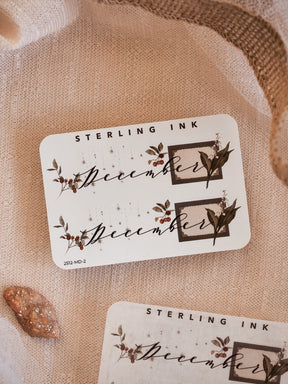 Sepia-toned decorative stickers featuring the month of December, adorned with elegant typography and seasonal leaf corner graphics for journaling or planning.
