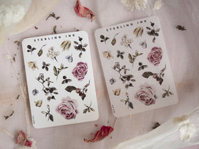 Botanical sticker set featuring delicate illustrations of lush pink roses, assorted leaves, and natural floral elements in muted green and mauve tones.