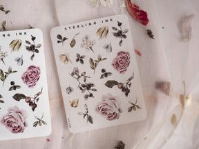 Set of elegant botanical sticker elements, showcasing realistic sprigs of dusty roses, deep green leaves, and delicate cream blooms in muted watercolor tones.