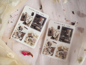 Detailed sticker sheet featuring vintage silver foil illustrations of distressed objects, old books, and decorative elements for a rustic December 2023 journal theme.