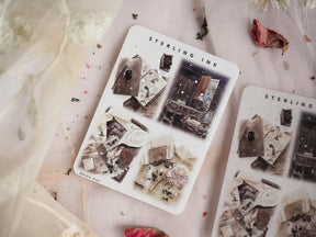 Vintage monochrome illustration stickers featuring aged, dark architectural scenes and scattered decorative silver foil accents from December 2023.