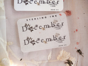 Pristine white labels featuring large, ornate dark lettering of "December" and coordinating calendar dates, perfect for vintage journaling and elegant scrapbooking.