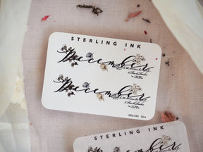 Elegant December month sticker featuring the word "December" in flowing script, beautifully framed by detailed black and brown botanical and floral elements.
