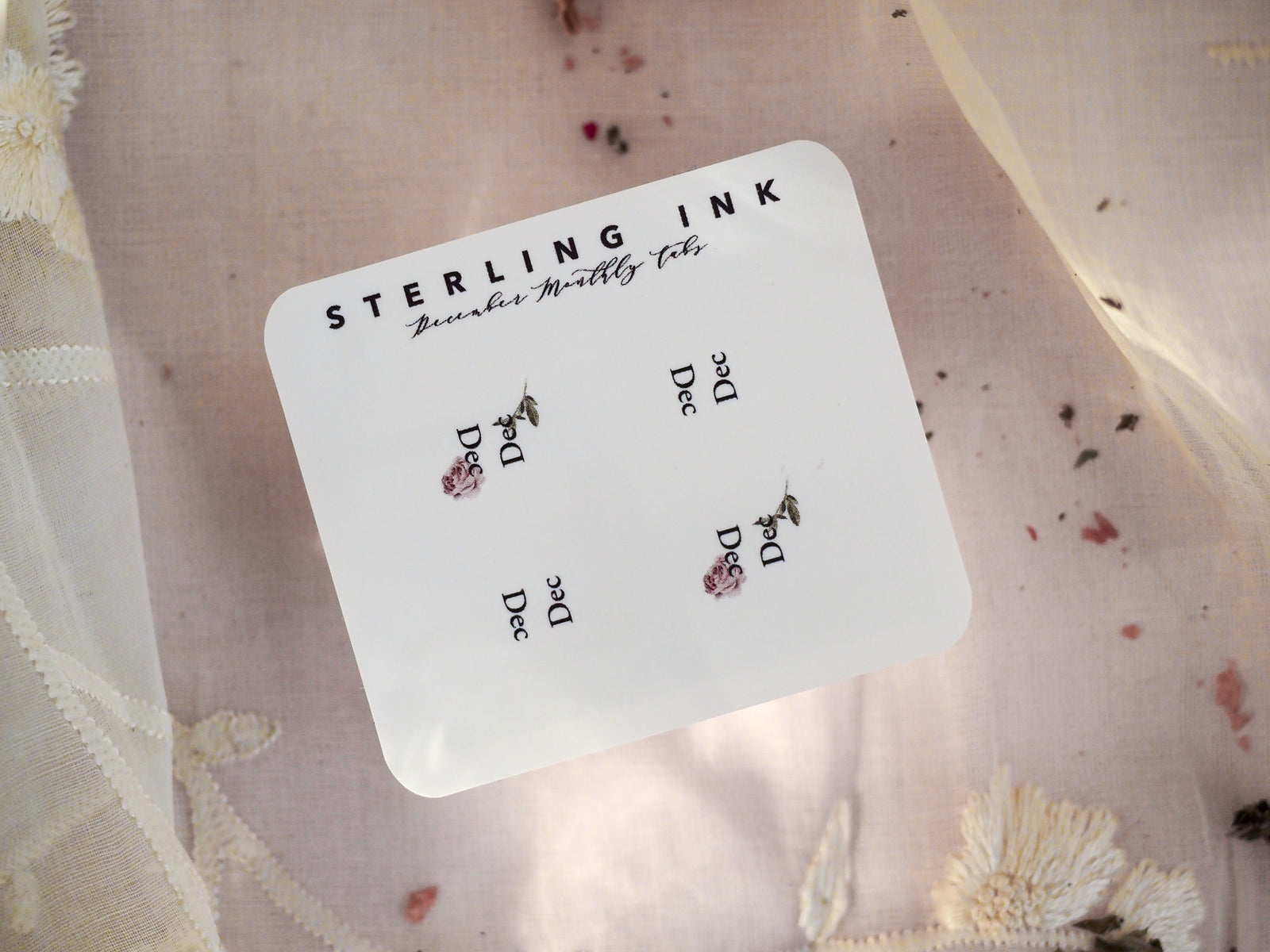 White monthly tab set with "STERLING INK" branding and charming, printed holly and berry motifs for December planning.