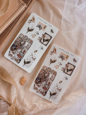 Illustrated arrangement sticker sheets featuring a rich December theme, showcasing intricate street scenes, seasonal foliage, and winter decorative borders.