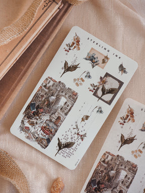 Seasonal arrangement sticker set featuring muted sepia tones, antique botanical wreath clusters, and intricate December street scene illustrations.