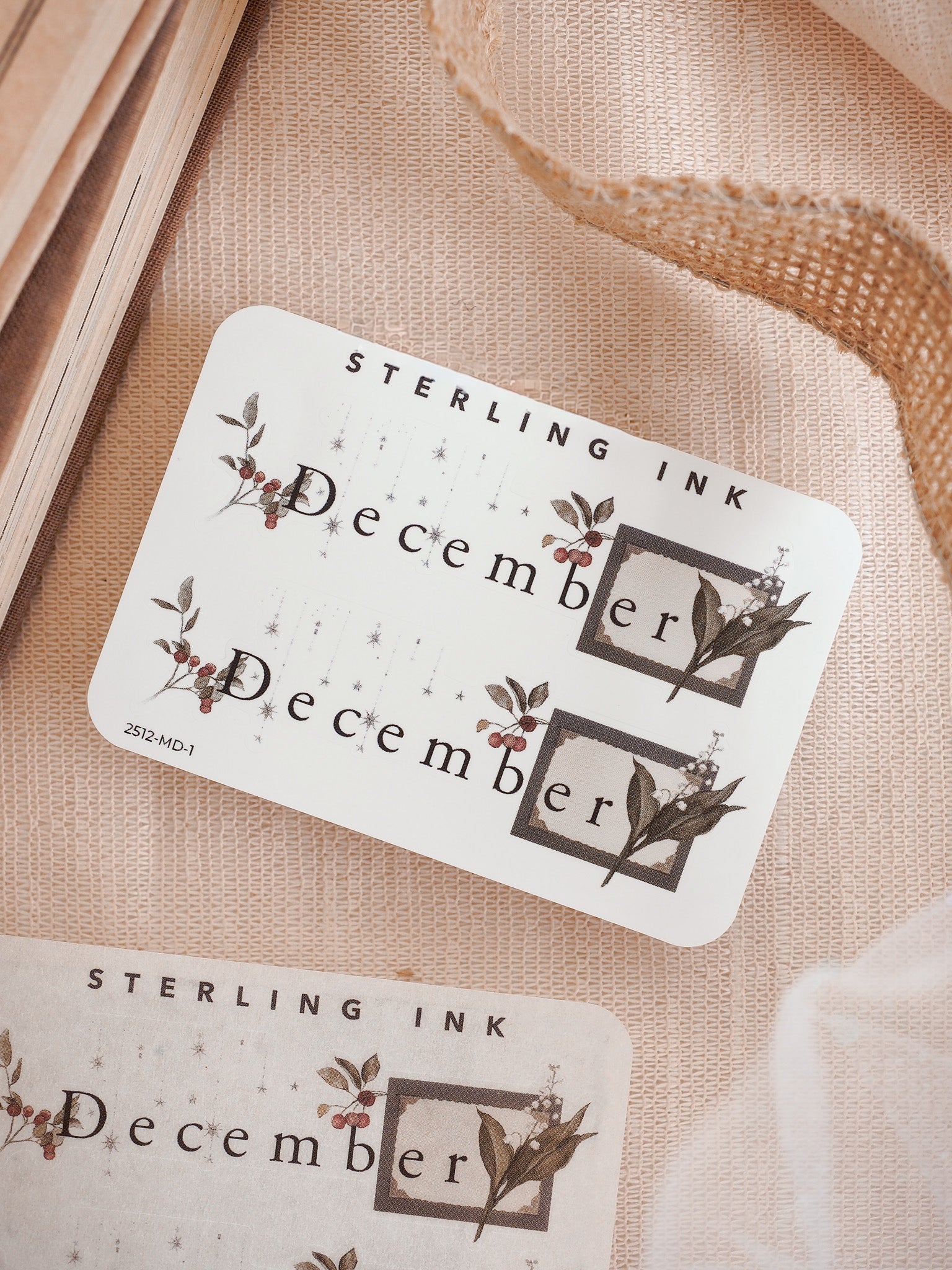 Decorative December month planner sticker featuring the word "December" in a brown floral frame with rustic berries and leaves.