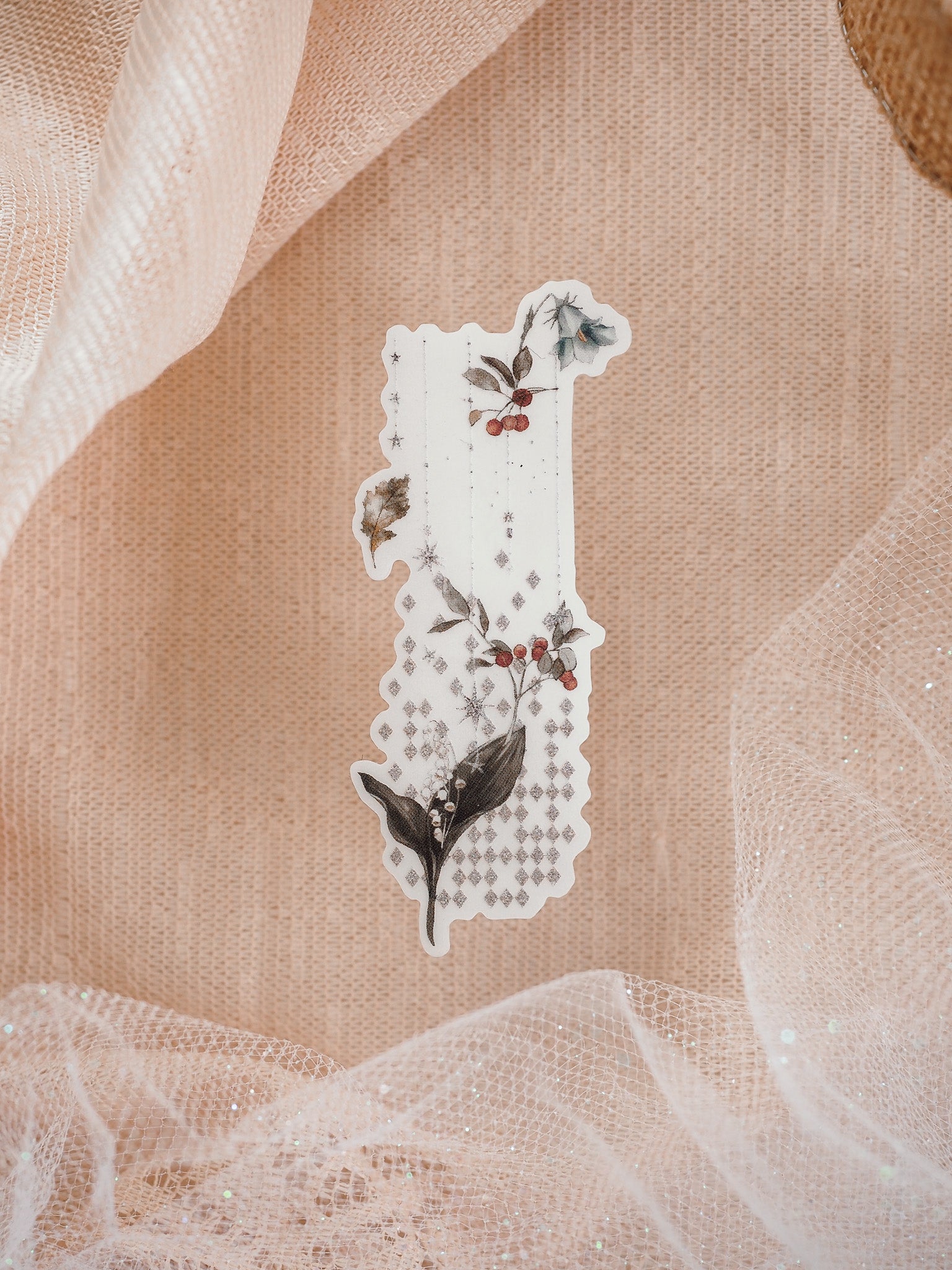 Rustic floral die-cut sticker featuring deep green foliage, red holly berries, and delicate star accents arranged vertically on clear vinyl.