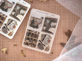 Festive sticker sheets displaying vintage, snowy December illustrations of brick buildings, evergreen wreaths, and cozy winter-themed decorative motifs.