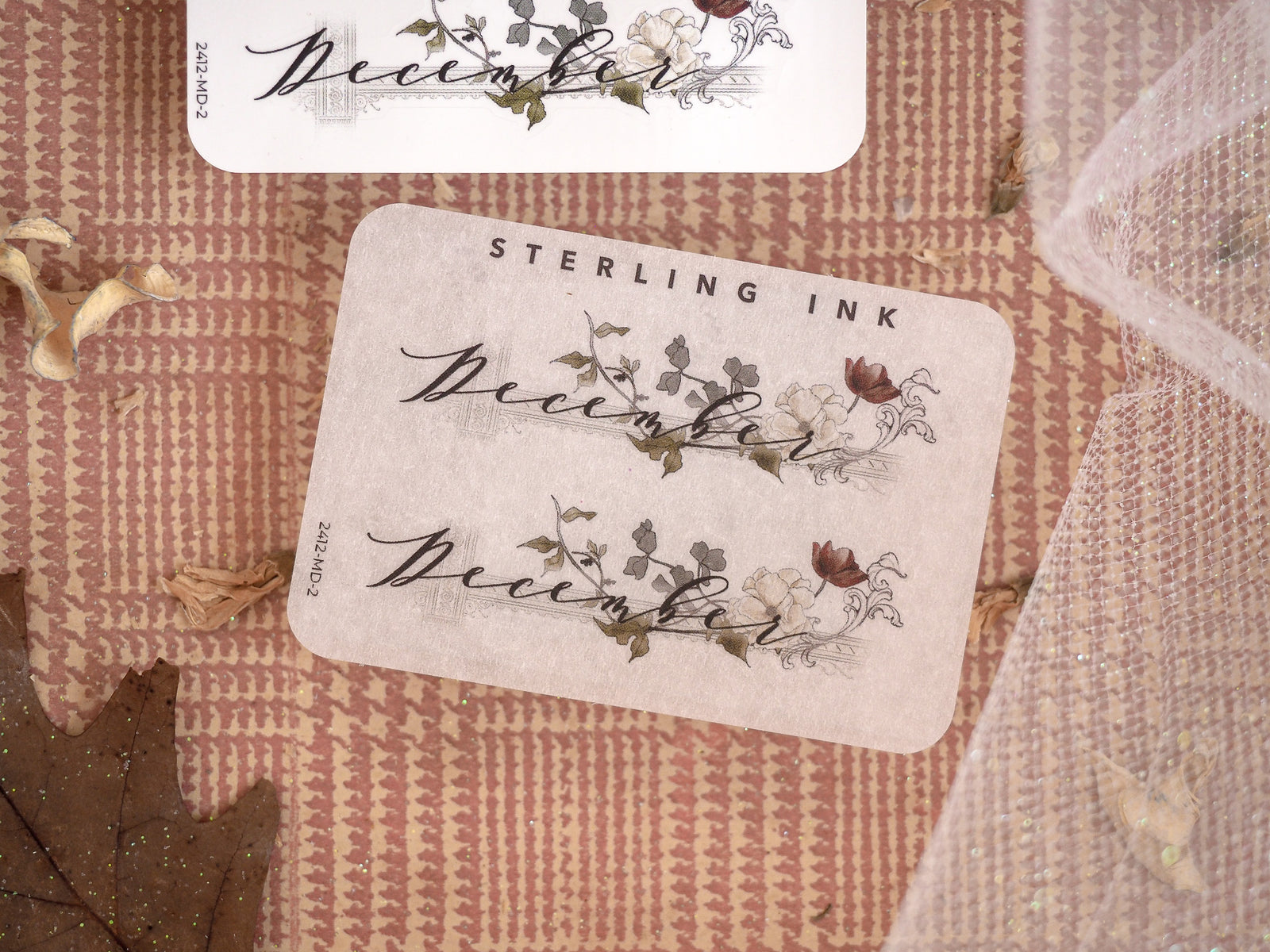 Elegant December month sticker featuring script lettering and delicate autumnal botanical illustrations in warm brown and blush tones.