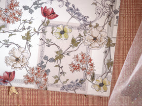 Elegant seasonal planner spread featuring a detailed botanical wreath pattern of autumnal flowers, cream blooms, and rich red accents on a pale background.