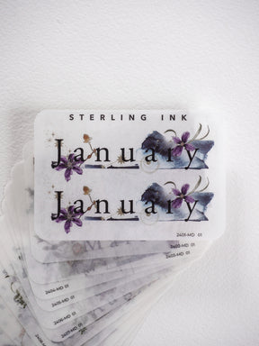Watercolor monthly planner stickers featuring the word "January" and elegant purple floral accents, perfect for journaling or scrapbooking.