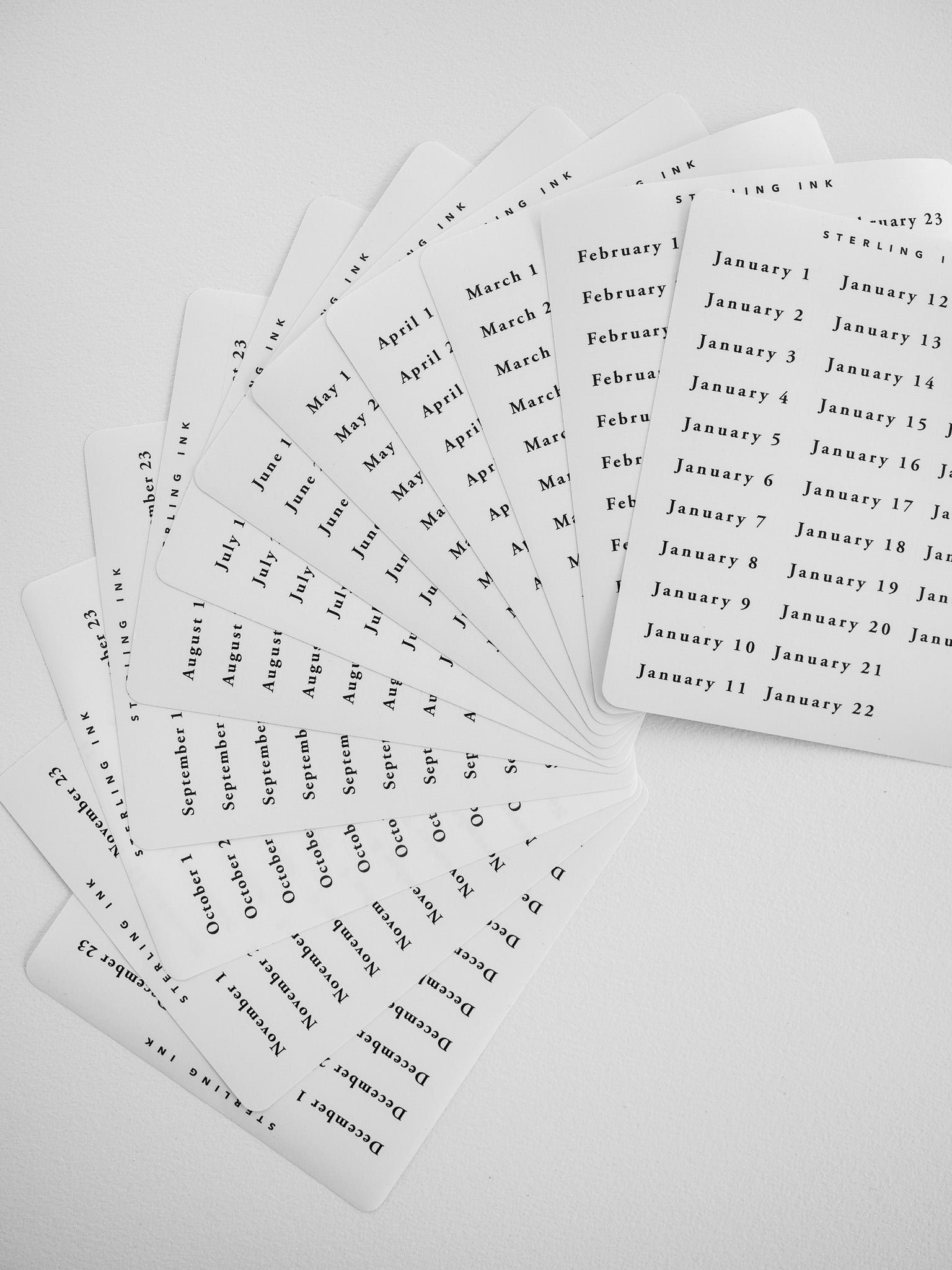 Daily calendar sticker packets featuring white, monthly sheets labeled January through December, perfect for seasonal date tracking and planning.