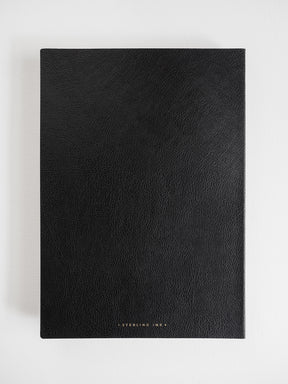 Minimalist B5 grid notebook featuring a sleek, textured matte black cover, perfect for deep journaling and planning.