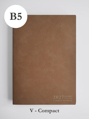 A brown textured 2027 compact planner shown closed on a light gray background, with a white circular label reading B5 at top left and the text 'V - Compact' below.
#Color_Caramel