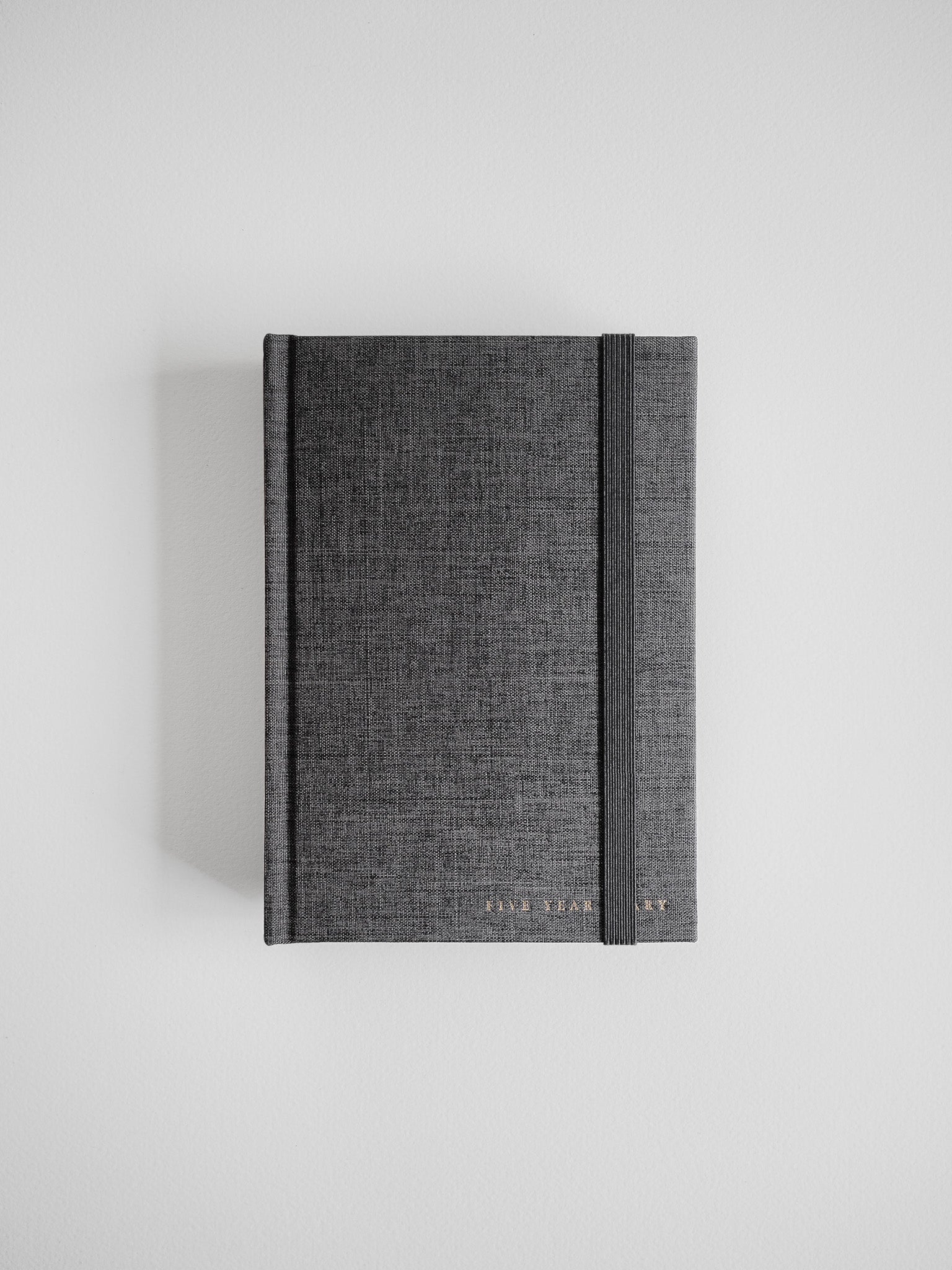 Textured charcoal gray B6 hardcover planner featuring a durable, minimalist design and elegant gold foil branding for a sophisticated look.