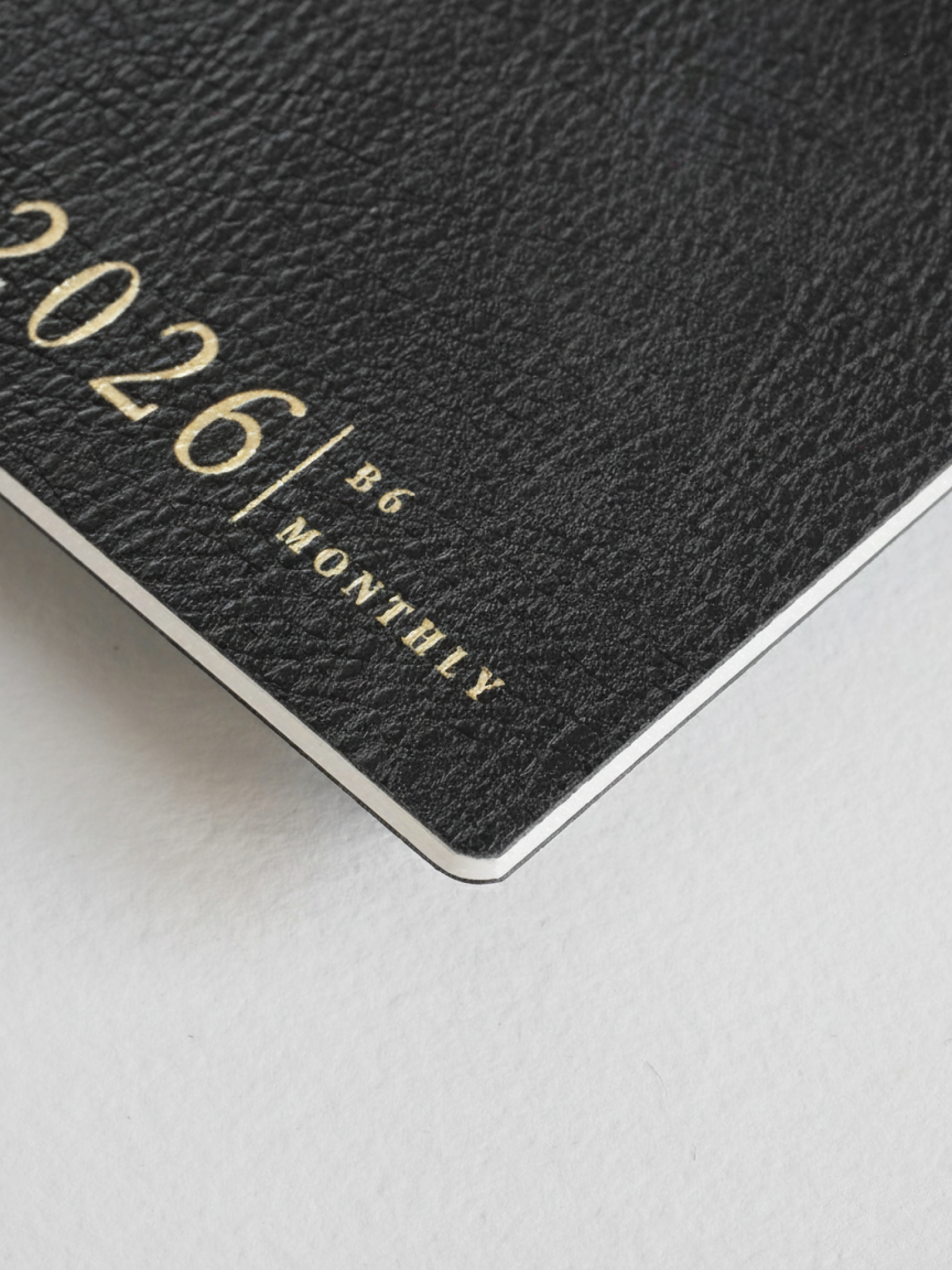 Matte black B6 monthly booklet cover displaying "2026 | B6 MONTHLY" in elegant, light silver lettering.