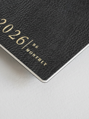 Matte black B6 monthly booklet cover displaying "2026 | B6 MONTHLY" in elegant, light silver lettering.
