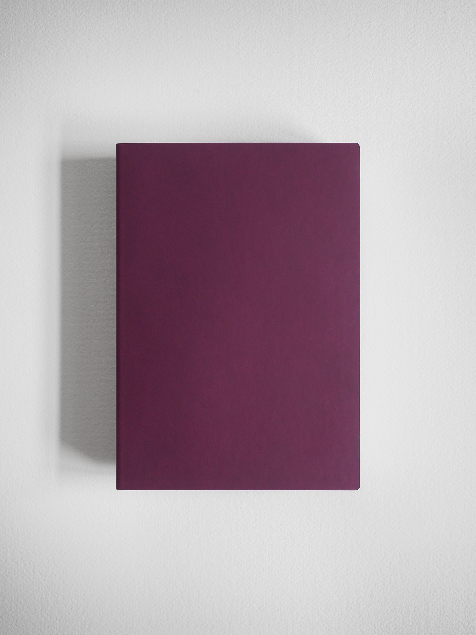 Plain B6 grid notebook featuring a solid, smooth deep plum-colored cover, perfect for journaling or sketching.