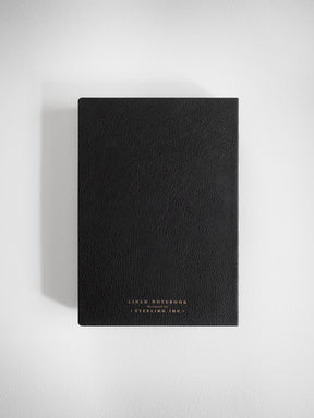Elegant black B6 lined notebook featuring a textured cover and subtle gold embossed lettering that reads "LINED NOTEBOOK," perfect for journaling.