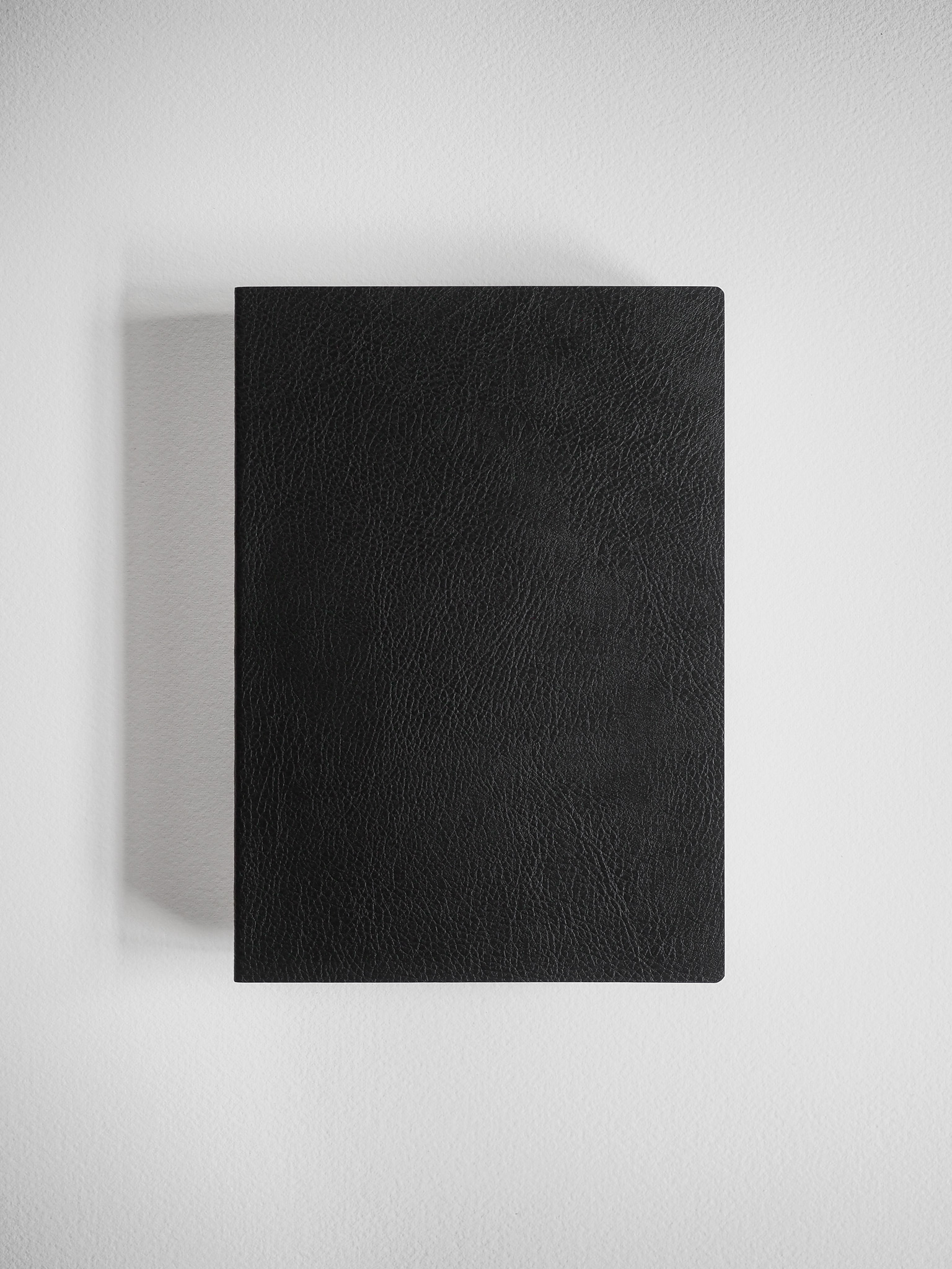 Matte black B6 grid notebook featuring a smooth, textured, leather-like cover perfect for journaling or academic notes.