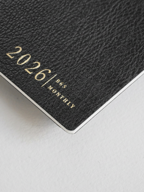 Charcoal-colored B6 monthly booklet cover featuring elegant, foil-stamped text that displays "2026/B6S MONTHLY" on a textured, sophisticated surface.