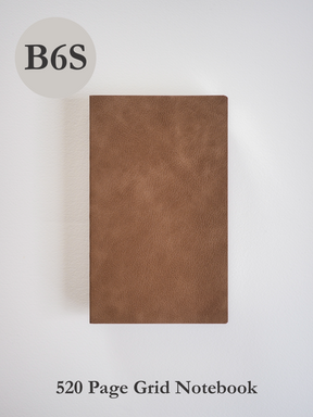 A slim B6 journal featuring a solid, smooth, tan brown cover with a rich, faux leather texture.