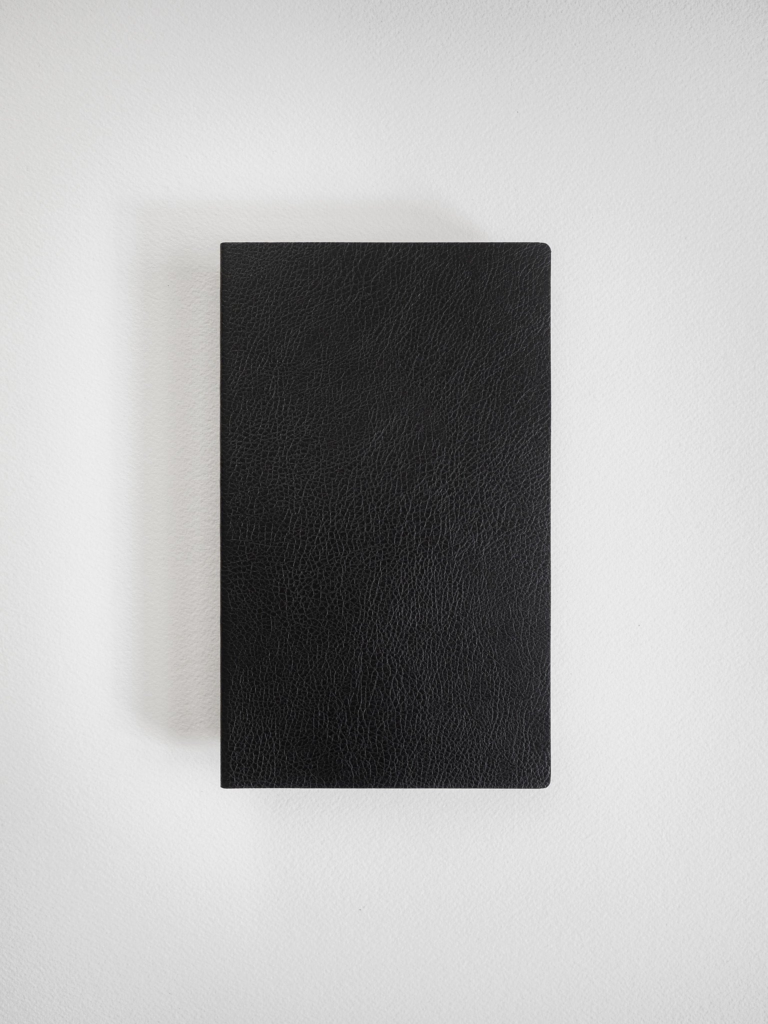 Solid black B6 notebook with a textured, faux-leather cover, offering a minimalist design for journaling or structured note-taking.