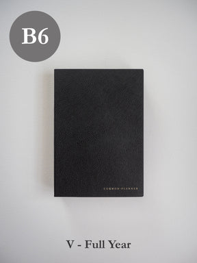 Minimalist black B6 vertical planner with a textured faux leather cover and discreet "Common Planner" branding, suitable for full-year undated use.