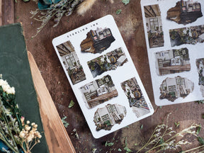 Torn paper sticker sheet designed with vintage, distressed architectural sketches of urban street scenes, ideal for scrapbooking journals.