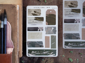 Assortment of decorative "Torn Tape" stickers with distressed, muted tones, including shades of ink, beige, and charcoal gray for journaling and crafting.