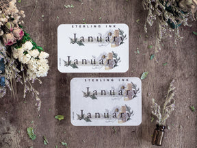 Elegant January month stickers featuring rustic botanical designs with watercolor greenery, delicate wood accents, and beautiful typography.