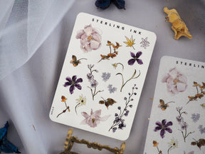 Watercolor sticker sheet featuring a collection of delicate botanical elements, including painted flowers, leaves, and small insects in soft pastels.