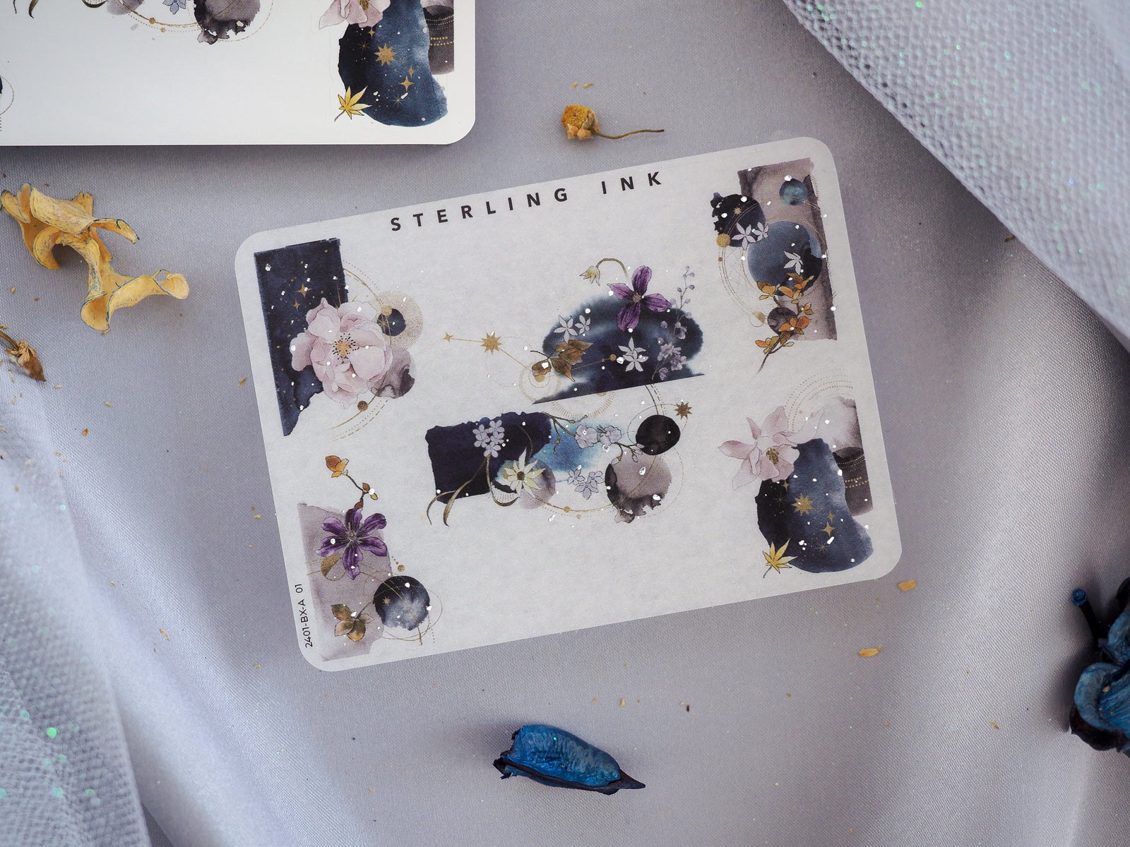Celestial corner stickers featuring deep navy backgrounds, glittering gold foil stars, and soft watercolor floral accents for journaling decor.