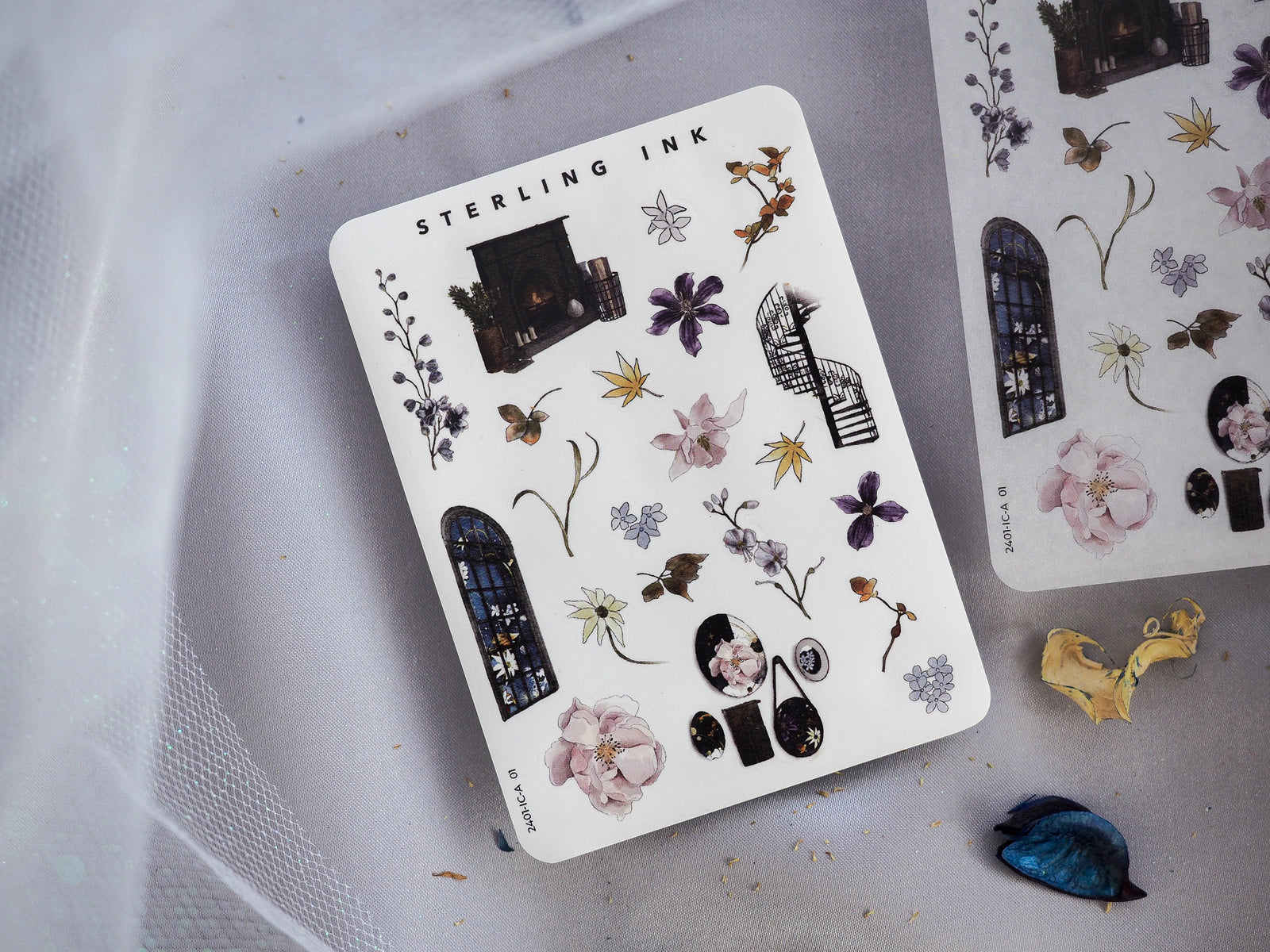 White sticker sheet featuring vintage botanical and architectural icons, including detailed flowers, gothic arched windows, insects, and various decorative elements from the "Sterling Ink" collection.