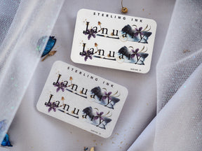 Elegant botanical January stickers featuring the name in scripted lettering and dark, vibrant purple watercolor floral accents.