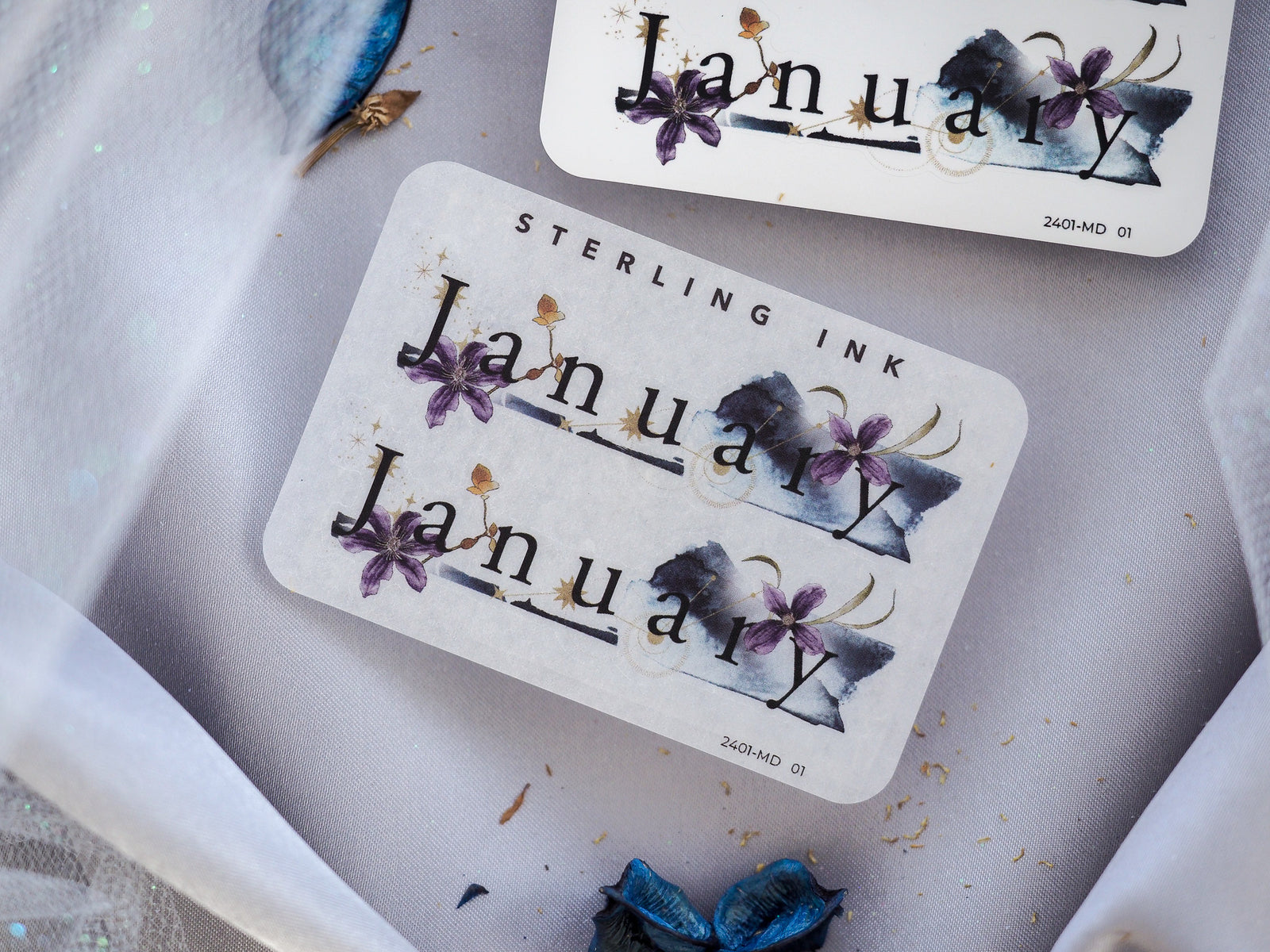 Elegant journaling sticker featuring "January" in a vintage font, surrounded by deep indigo watercolor flowers and washes.