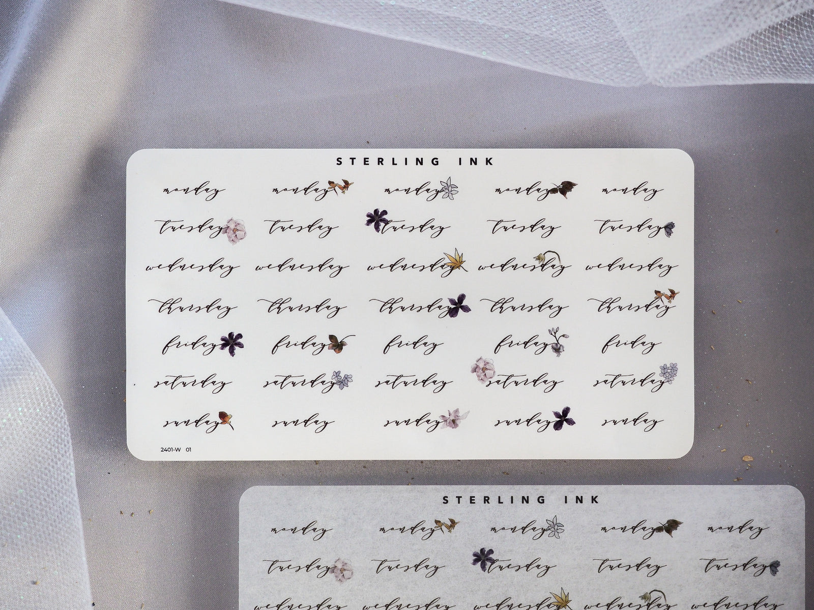 Decorative black-ink sticker sheet for journaling, featuring whimsical weekly labels for the days of the week and delicate floral accents.