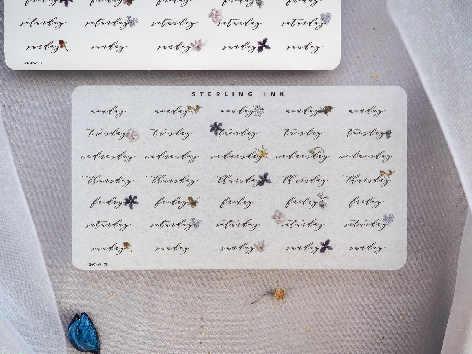 White planning stickers for January 2024 featuring elegant, handwritten "weekday" titles and decorative small gray floral accents.