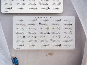 White planning stickers for January 2024 featuring elegant, handwritten "weekday" titles and decorative small gray floral accents.