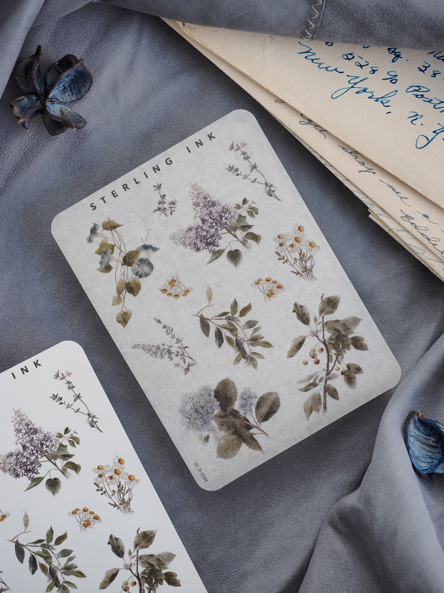 Botanical sticker elements featuring delicate, vintage illustrations of foliage and wildflowers in muted sage and sepia tones.