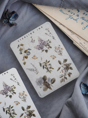 Botanical sticker elements featuring delicate, vintage illustrations of foliage and wildflowers in muted sage and sepia tones.