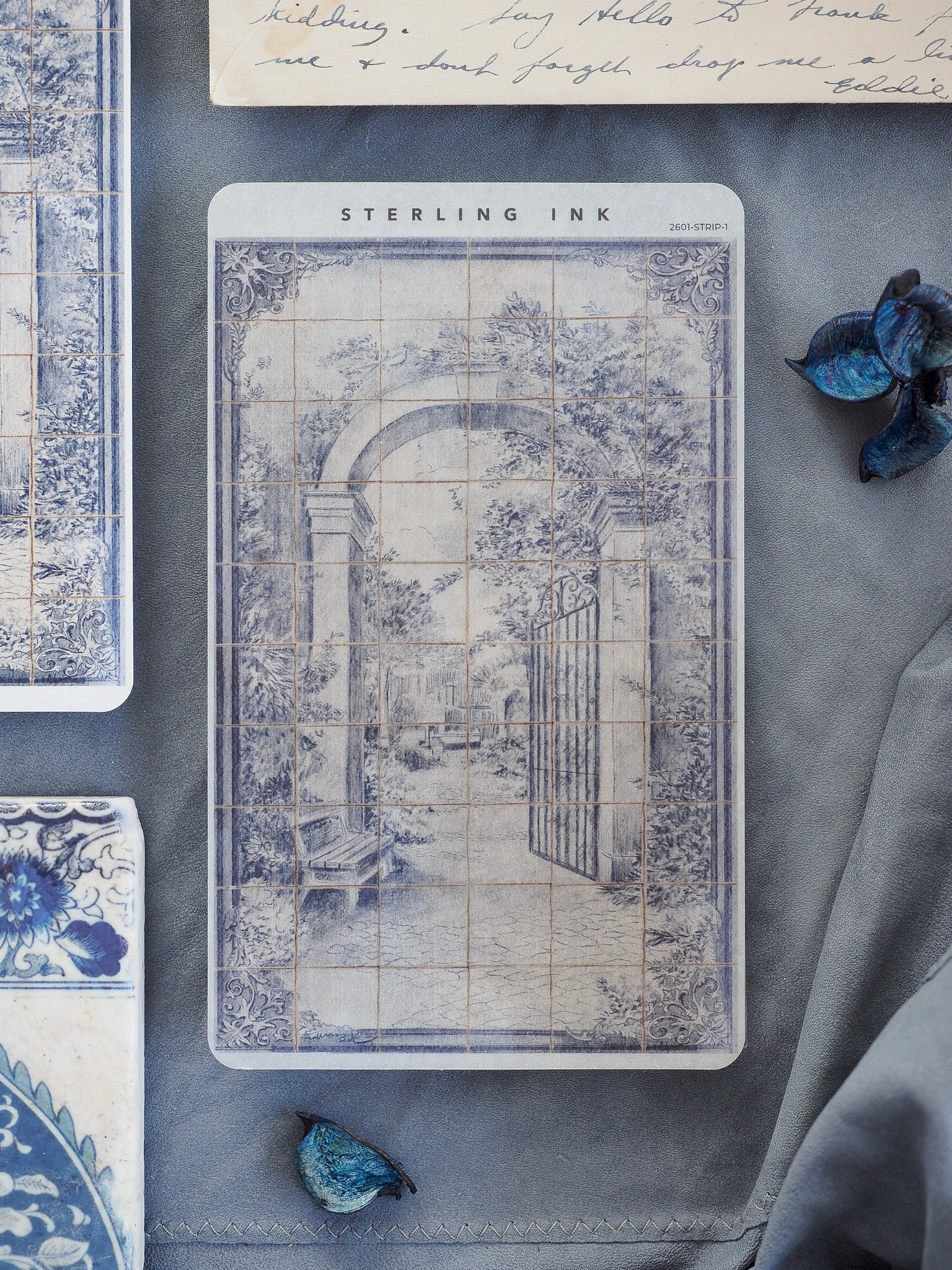 Vintage, monochromatic sticker featuring an arched garden entrance and wrought iron gate framed by lush, overgrown foliage and rendered in delicate blue-gray ink.