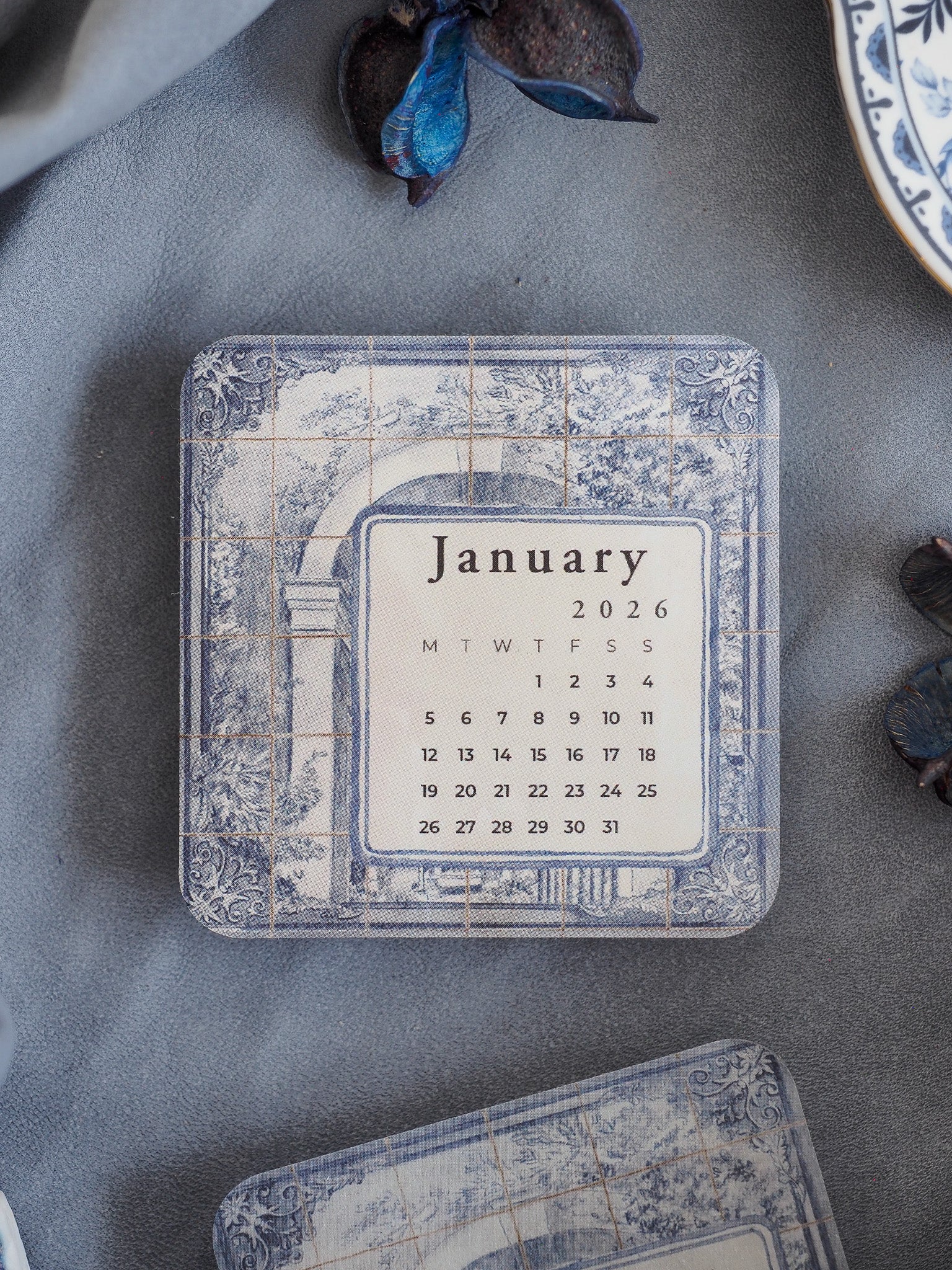 Antique-style January 2026 calendar card featuring a printed grid set within an elegant, distressed pale blue and gray tiled frame.