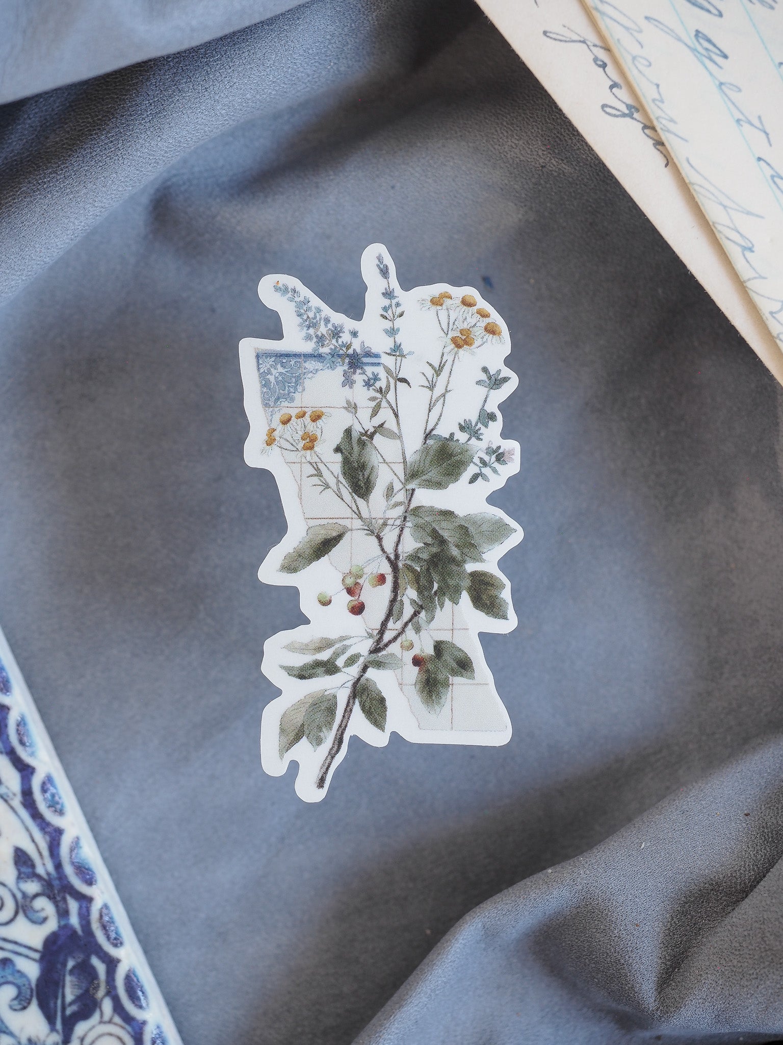 Detailed floral die-cut sticker showcasing a natural arrangement of green leaves, delicate yellow blossoms, and clustered red berries.