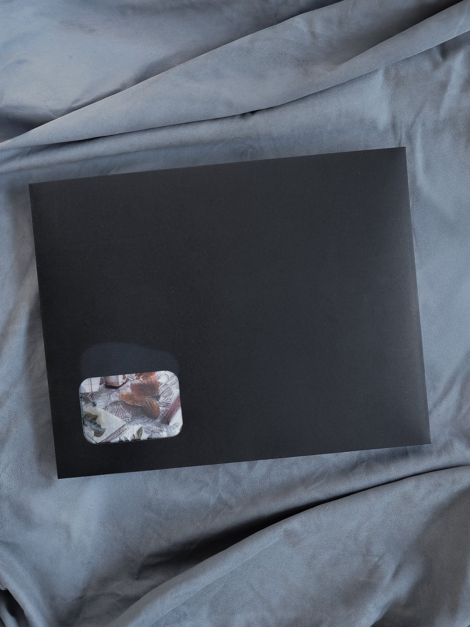 Sleek black planner kit featuring a small, contrasting corner patch adorned with muted, organic botanical prints and earthy tones.